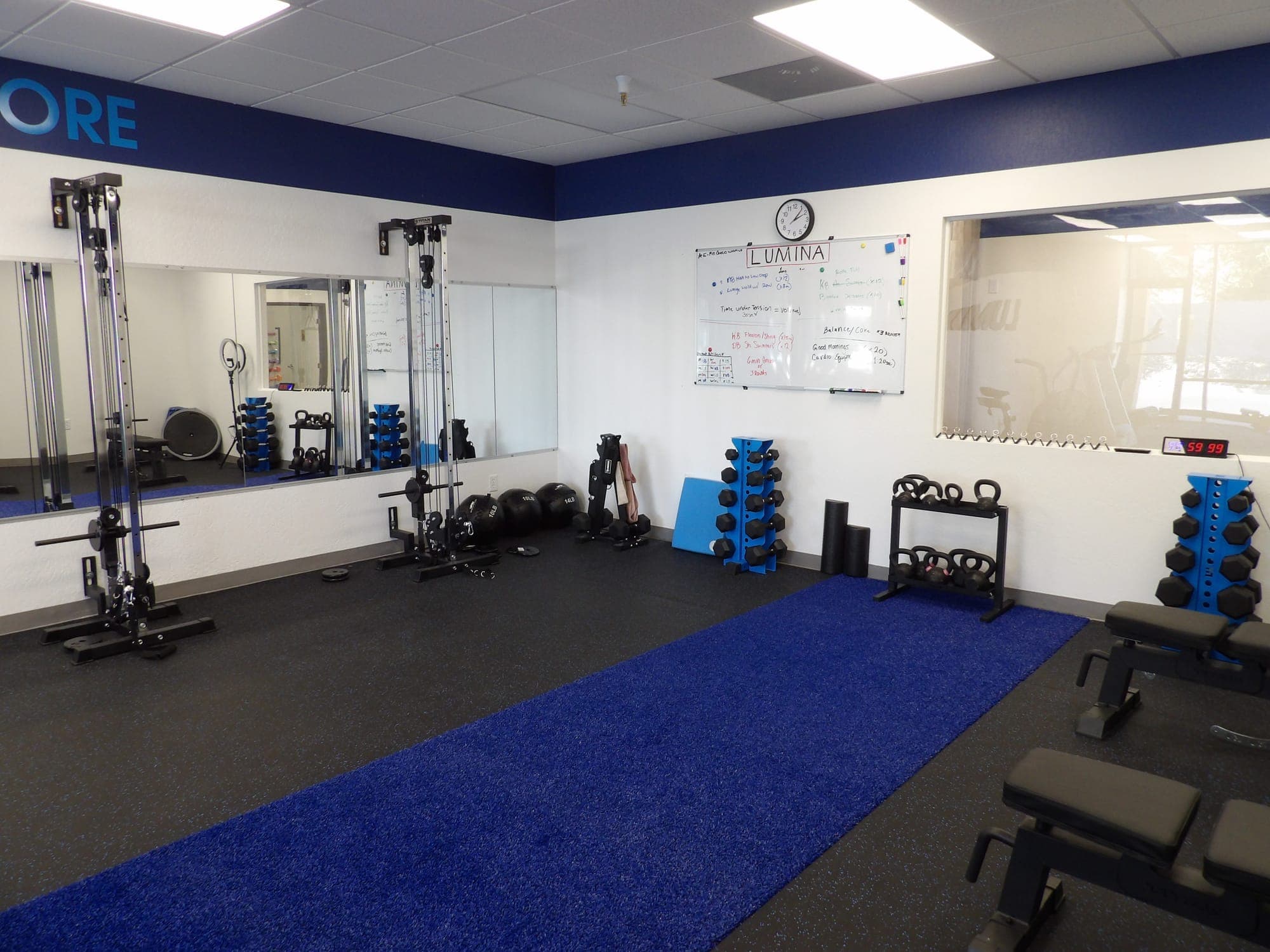 Turf training lane with kettlebells, dumbbell towers, medicine balls and adjustable benches at LUMINA