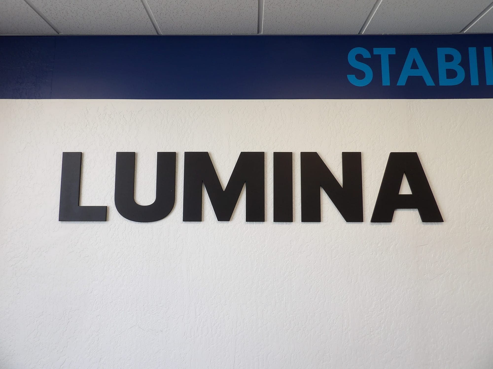 LUMINA sign on the studio wall under a Stabilize and Strengthen banner
